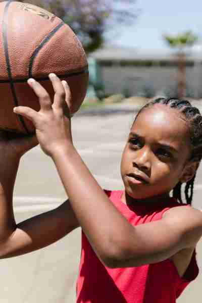 A young girl shooting a basketball.